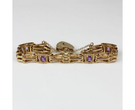An Edwardian style amethyst and 9ct gold bracelet, the gate link bracelet set with four amethysts within florally engraved bo
