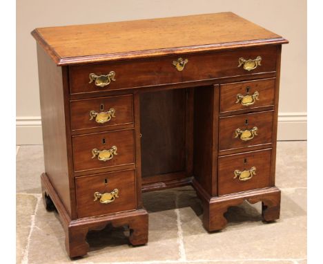 A George III mahogany knee-hole desk, the moulded top over a later compartmented frieze drawer and an inverted cupboard door,
