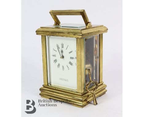 Brass carriage clock. The clock having a white enamel face with Roman dial, shown to be retailed by Garrard &amp; Co Ltd, bev