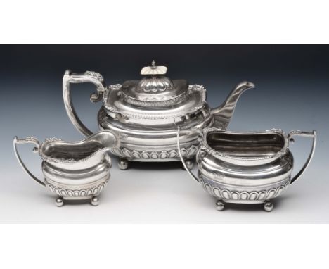 Silver three piece tea set comprising a teapot, a sugar basin and a milk jug with relief borders, half fluted bodies, bun sup