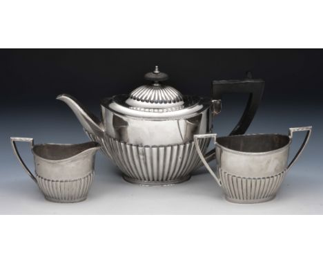 Three piece silver tea set of tapering form with reeded borders, half fluted bodies and shaped handles, Sheffield 1910, 704 g