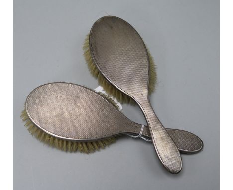 Two 1950's engine turned silver mounted hair brushes.