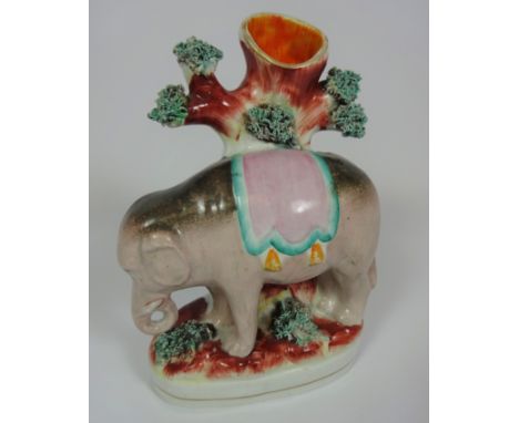 Victorian Staffordshire spill vase in the form of an elephant standing in front of a tree trunk, H17cm approx   Condition Rep