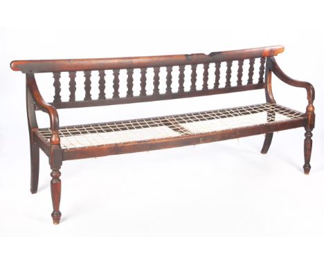 With shaped toprail above shaped splats, riempie seat, downswept arms on turned and ring-turned legs220cm long
