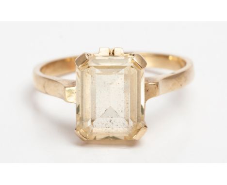 Claw set to the center with an emerald cut gemstone possibly Topaz , weight approximately 2.5 carats in 9ct yellow gold, ring