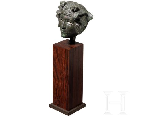 Bronzeapplik mit Kopf des Dionysos, römisch, 1. - 2. Jhdt. n. Chr.  Hohl gearbeitete Applik aus massiver Bronzewandung mit ei
