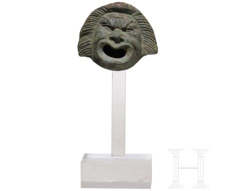 Bronzeapplik in Form einer Maske der Neuen Komödie, römisch, 2. - 3. Jhdt. n. Chr.  Ins Groteske gesteigerte Züge einer Maske