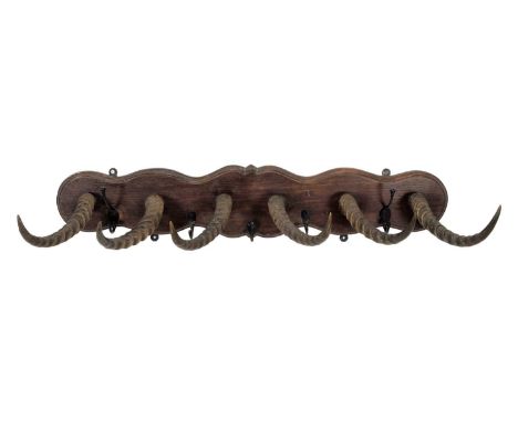 Animal Furniture: A Late Victorian Horn Mounted Coat Rack, a shaped oak wall bracket fitted with six African Kob horns mounte
