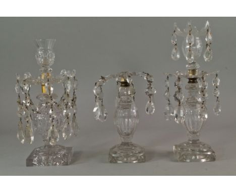 A pair of glass single light lustre hung candle sticks, 19th century, with bulbous stems, on square bases, damages and losses