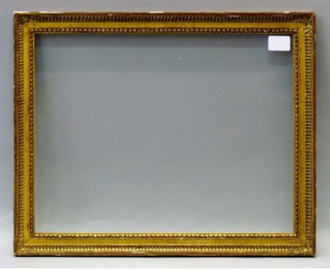 A French Carved and Gilded Louis XVI Style Frame, early 19th century, with pearl bead sight, frieze, fluted hollow and plain 