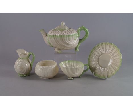 A Belleek porcelain tea service, 19th century, overall moulded in a shell form and decorated with green glazing to rims, to c