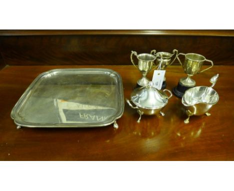 A collection of Epns wares to include a tray of square form on hoof feet, cream jug, sugar bowl and three trophy cups (a lot)