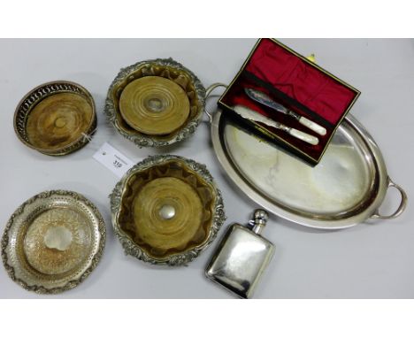 A mixed lot to include three silver plated wine slides, an Epns card tray, a hip flask and mother-of-pearl handled butter kni