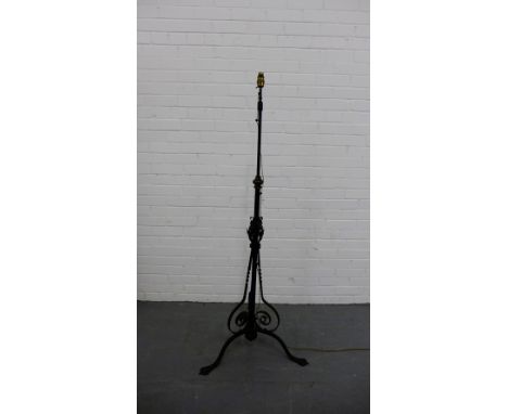 A wrought iron standard lamp on tripod supports, 154cm high