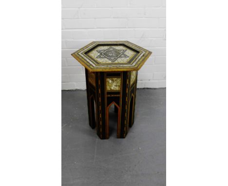 An Eastern inlaid hexagonal topped table with star motif and mother-of-pearl panels on parapet style supports, 50 x 39cm