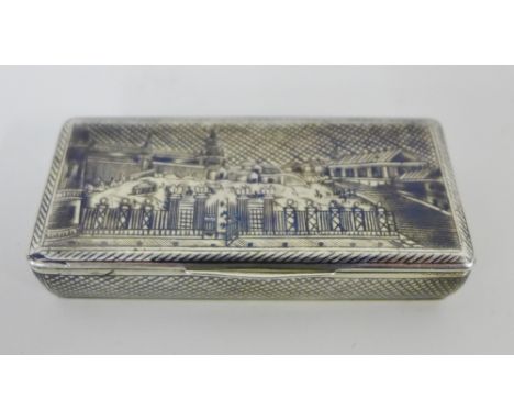 A 19th century Russian silver and niello work snuff box with a gilt interior, the hinged lid with the grounds and architectur