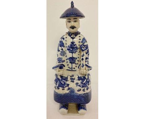 A Chinese ceramic blue and white figurine of a seated gentleman. His robes decorated with dragon detail. Impressed marks to b