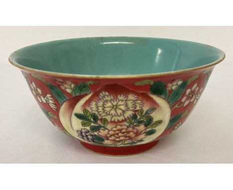 A Chinese ceramic bowl with decorative outer bowl and blue/green glaze interior. Red ground outer bowl decorated with peaches
