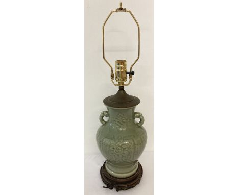 A Chinese celadon glazed, 2 handled lamp base with floral design and brass light fitting. Needs rewiring. Base approx. 30cm t