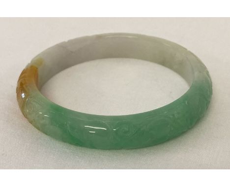 A small jade bangle with engraved detail.  Approx. 7.5cm diameter.