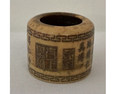 A Chinese white jade archers ring with engraved calligraphy detail.  Approx. 3cm tall x 3.75cm diameter.