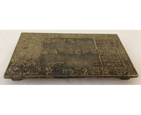 A large Chinese brass rectangular shaped scroll weight with Chinese symbol detailing to top. Raised on 4 stepped feet. Approx