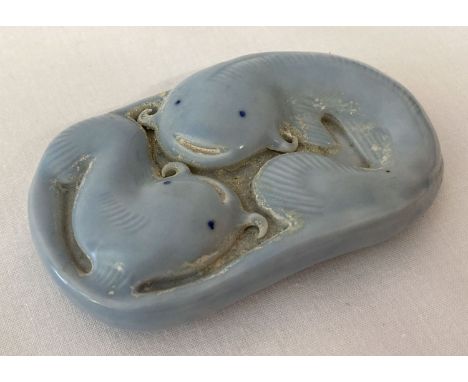 A blue porcelain Chinese scroll weight depicting fish. Signed to base with Chinese symbols. Approx. 8.5cm x 5cm x 1.5cm.