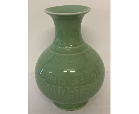 A green glazed Chinese ceramic vase of bulbous form with wide lipped neck. Signed to underside. Approx. 26.5cm tall.