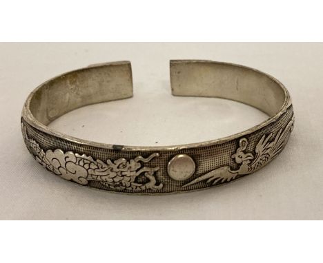 A Chinese white metal bangle featuring a dragon and a phoenix.  Approx. 7.5cm diameter.