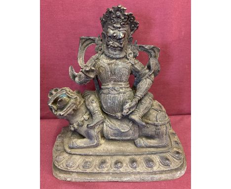 A large hollow bronze figurine of an Oriental Deity sitting atop a Foo dog.  Approx. 28cm tall x 26cm wide.