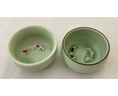 2 small ceramic Chinese bowls with fish detail to inner bowl, in pale green glaze.  Both approx. 6cm diameter.