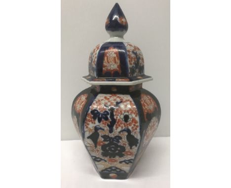 An oriental ceramic hexagonal ginger jar of blue and orange colouration. Conical decoration to lid. Approx 32cm tall includin
