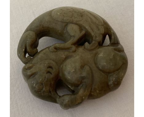 A Chinese Jade roundel depicting Mythical creatures. Carved detail to both side.  Approx. 5cm diameter.
