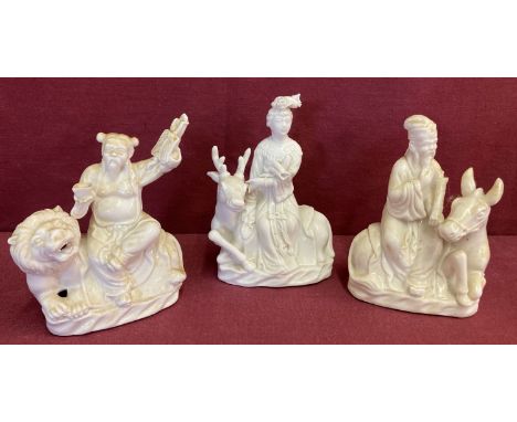 3 Chinese ceramic blanc de chine figurines depicting figures sitting atop animals.  Approx. 14cm tall.