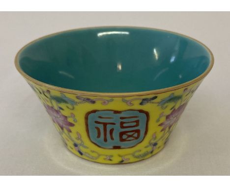 A small Chinese ceramic tea bowl with colourful floral detail and panel design to outer bowl. Blue/green glaze to interior. P