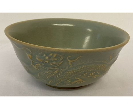 A Chinese ceramic bowl with pale blue glaze and dragon and phoenix design to outer bowl.  Approx. 7cm tall x 15.5cm diameter.