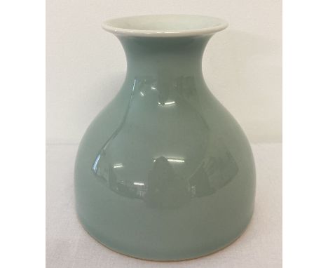 A pale green/blue glazed wide bottomed vase with signature to underside.  Approx. 10cm tall.