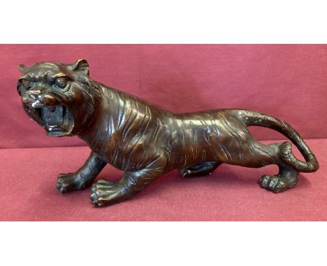 A hollow bronze figurine of a roaring tiger.  Approx. 16cm tall x 31cm long.