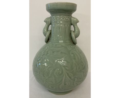 A large 2 handled celadon glaze vase of bulbous form, with floral and leaf decoration. Ring detail to handles. Approx. 38cm t