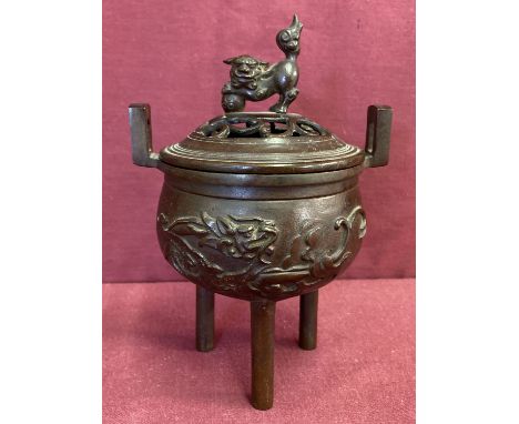 A Chinese bronze lidded censer with pierced work detail to lid and foo dog finial. Raised on 3 tripod tubular legs and with d