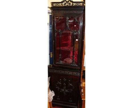 A circa 1900 Chippendale Revival mahogany corner cupboard, having single door glazed upper section with carved and pierced fl