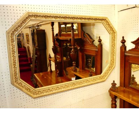 A white finished acanthus leaf decorated chamfered octagonal wall mirror, 59 x 94cm; together with a white painted bevelled o