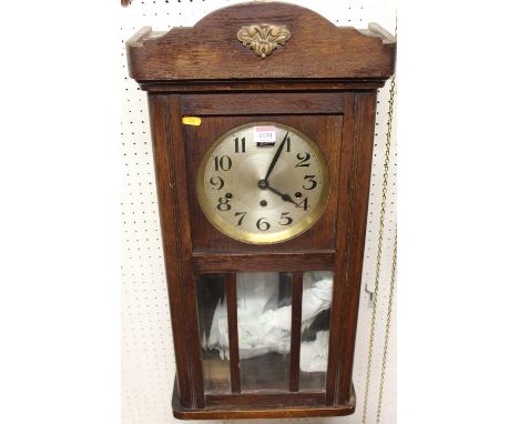 A 1930s oak drop trunk wall clock, having striking and chiming movement, height 80cm