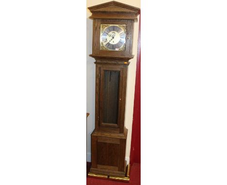 A contemporary oak long case clock, having a silvered and brass dial, striking and chiming movement with three weights and pe