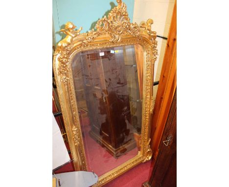 A contemporary French style gilt floral and cherub decorated arched bevelled wall mirror, with crested floral surmount, 159 x