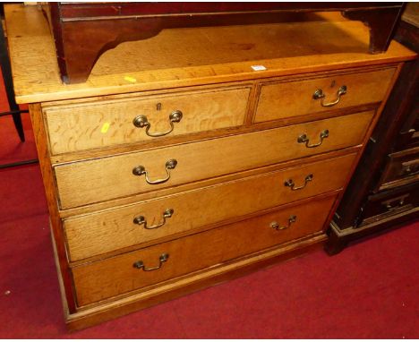 An early 20th century light oak ledgeback chest, of two short over three long graduated drawers with brass swan-neck handles,
