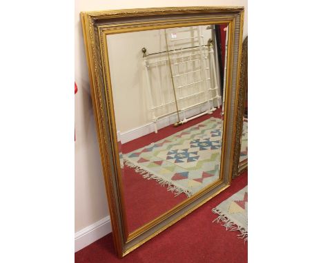A large contemporary gilt decorated bevelled rectangular wall mirror, 144 x 112cm