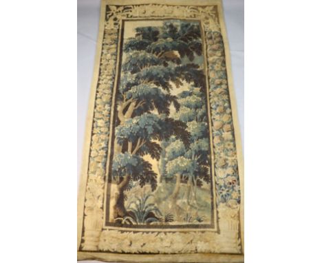 A 17th century Flemish verdure tapestry wall hanging, with central panel of trees withing flower and urn border, 8ft 1in. x 3
