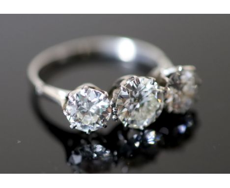 A platinum and three stone diamond ring, the central stone weighing approximately 1.20ct and the two outer stones approximate