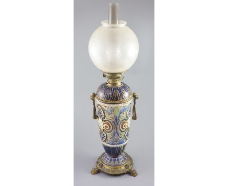 A large Doulton Lambeth stoneware oil lamp, by Edith D. Lupton, dated 1880, decorated with cherub heads and incised foliage i